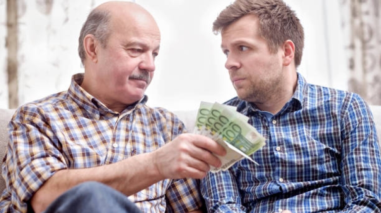 Elderly father lends money to his adult son. He helps his child deal with financial problems.