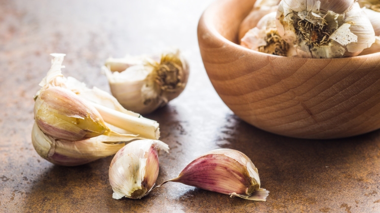 Fresh healthy garlic on kitchen table.