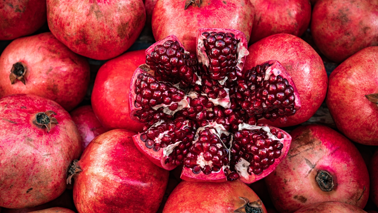 Red pomegranate fruit at street market. Group of pomegranates